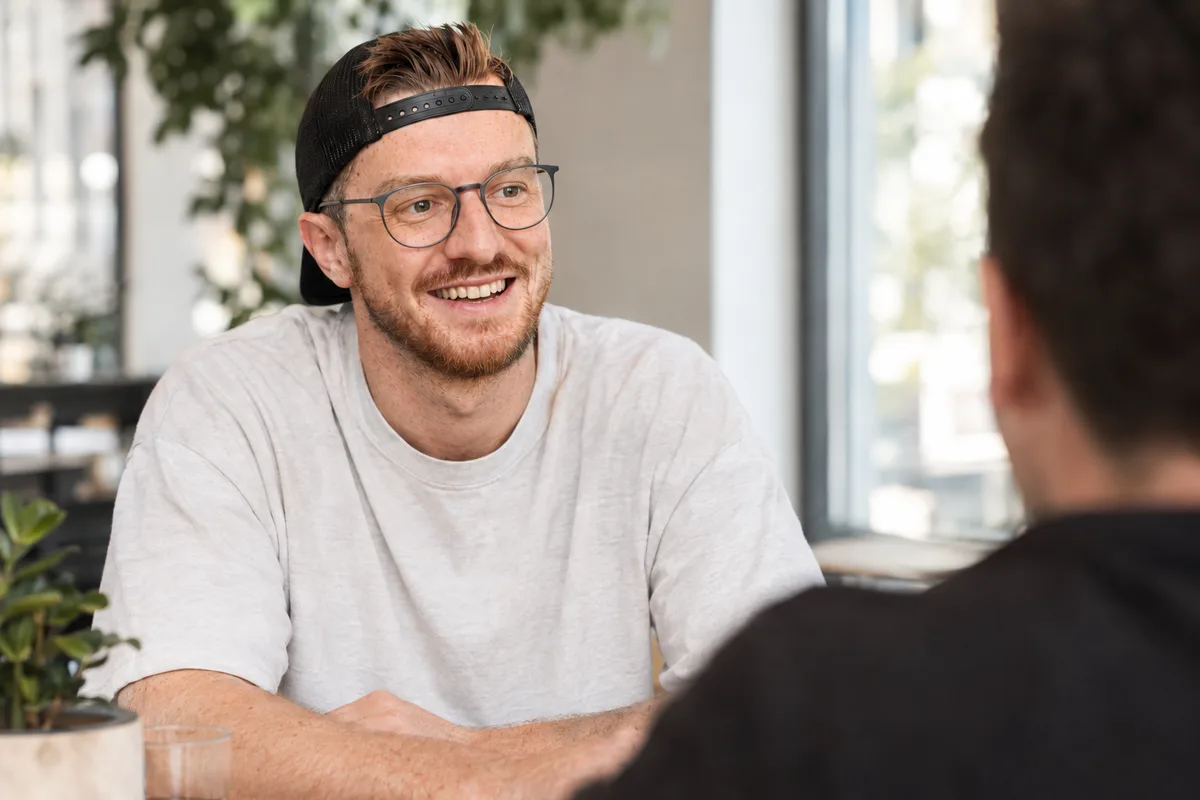Markus Kober im Gespräch mit einem Kunden, Laptop auf dem Tisch